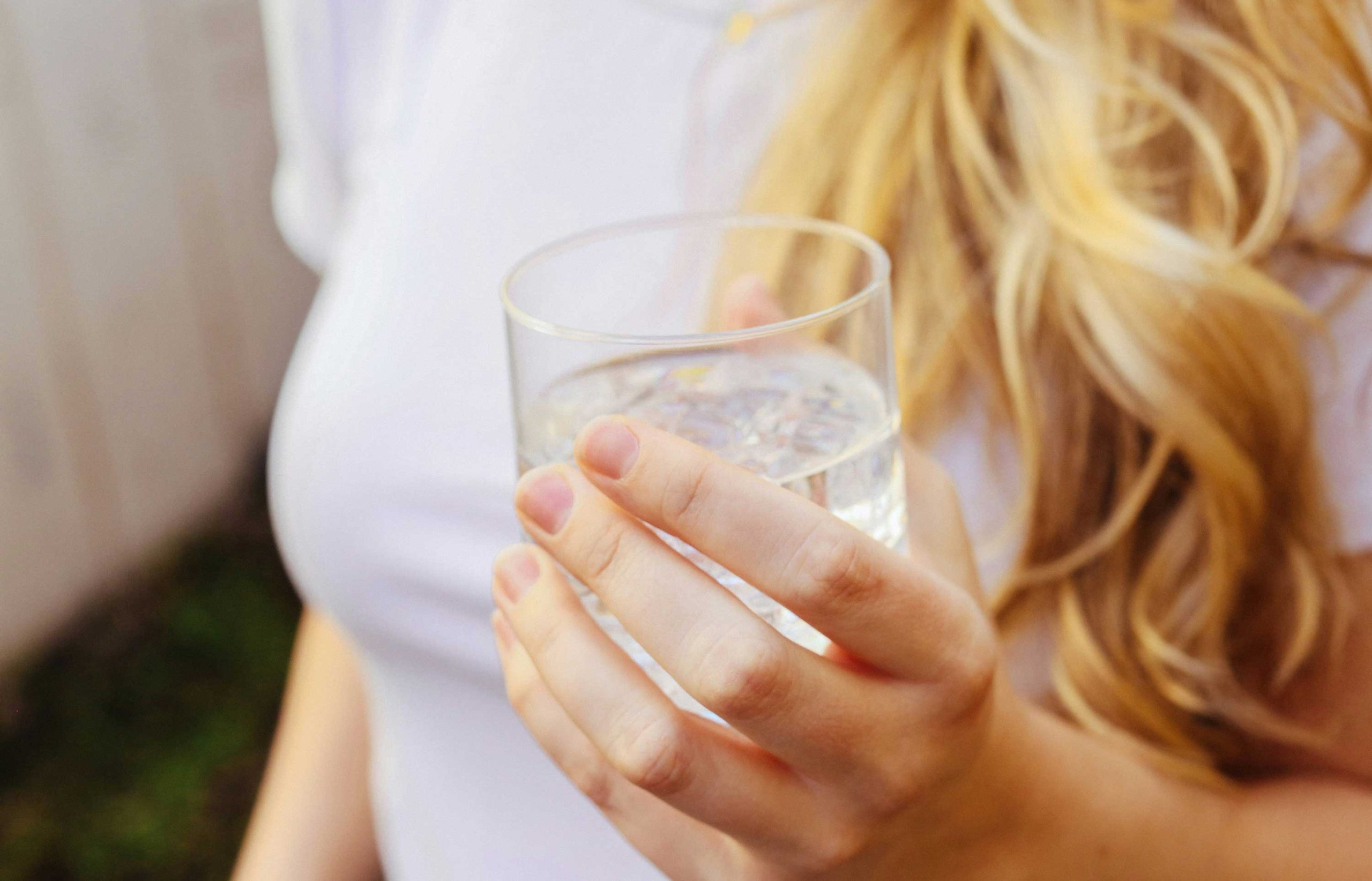 Blonde woman holding a glass of water